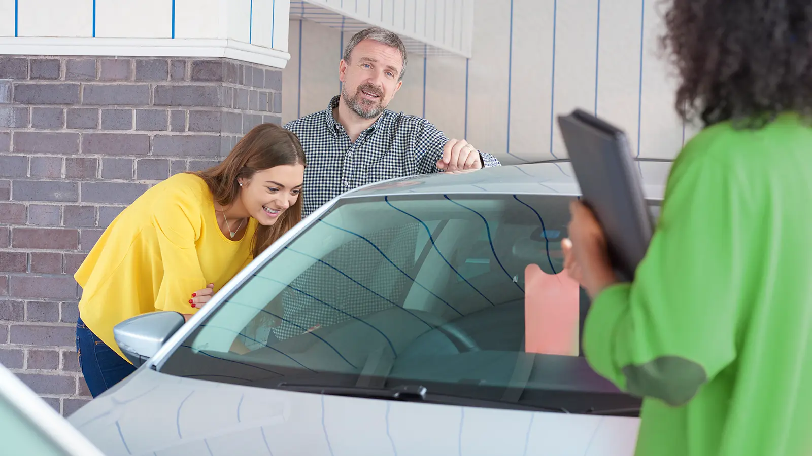 Man and young girl buying her first car